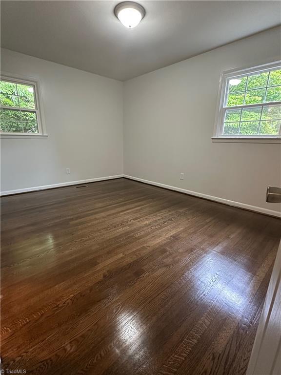 1230 W Sedgefield Dr, Winston-Salem, NC 27107 - spare room featuring dark wood finished floors, plenty of natural light, and baseboards