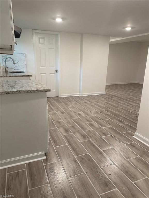 1230 W Sedgefield Dr, Winston-Salem, NC 27107 - below grade area featuring wood tiled floors, a sink, baseboards, and recessed lighting