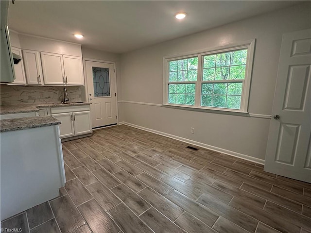 1230 W Sedgefield Dr, Winston-Salem, NC 27107 - kitchen with white cabinetry, a sink, light stone counters, tasteful backsplash, and wood tiled floors
