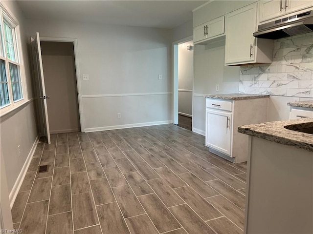 1230 W Sedgefield Dr, Winston-Salem, NC 27107 - kitchen featuring under cabinet range hood, light stone counters, wood finished floors, backsplash, and baseboards