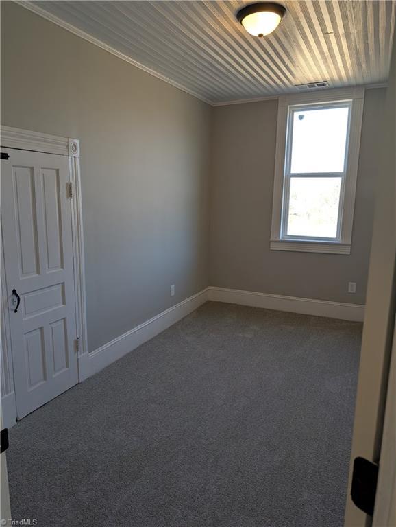 carpeted spare room featuring ornamental molding