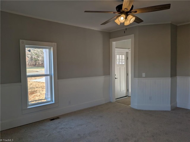 unfurnished room with ceiling fan, crown molding, and light colored carpet