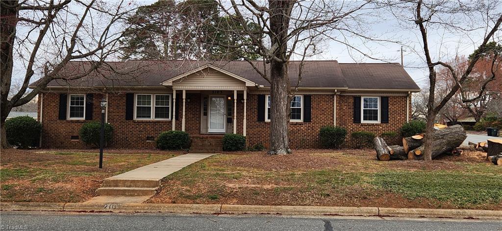 view of front facade featuring crawl space, brick siding, and a front lawn