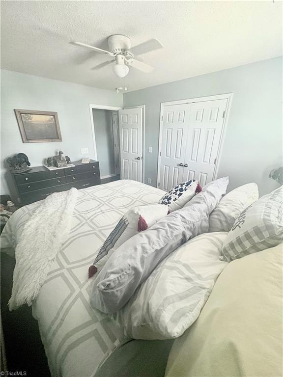 1620 Cherry Blossom Ln Unit 301, Winston-Salem, NC 27127 - bedroom with a closet, ceiling fan, and a textured ceiling