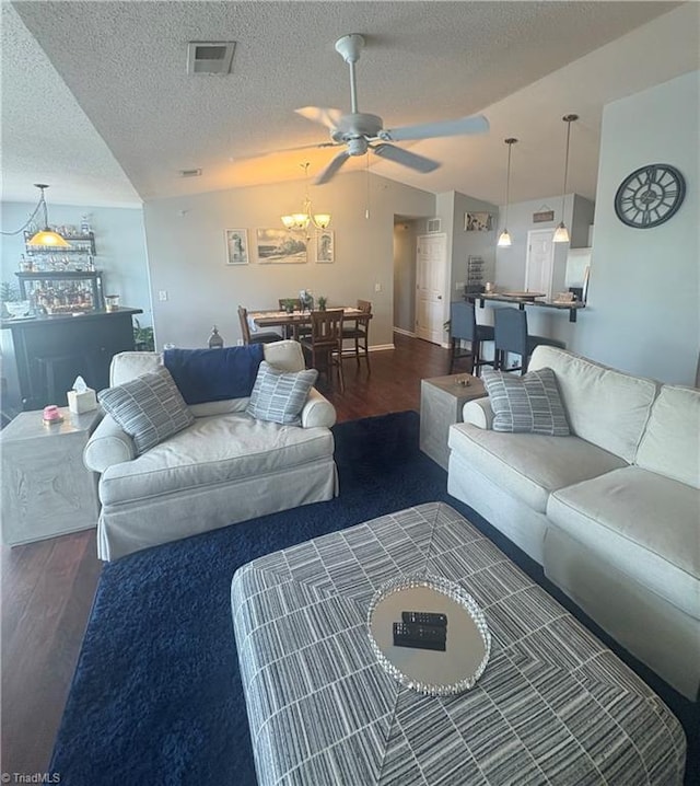 1620 Cherry Blossom Ln Unit 301, Winston-Salem, NC 27127 - living room featuring lofted ceiling, wood finished floors, a ceiling fan, a textured ceiling, and a chandelier