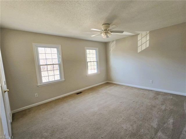 carpeted spare room featuring a textured ceiling and ceiling fan