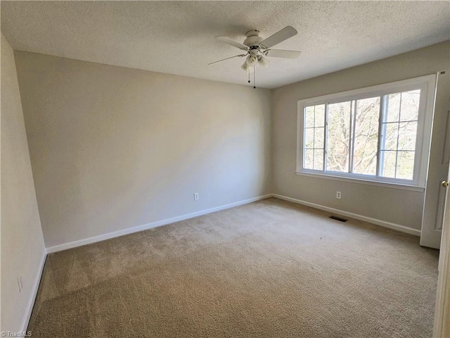 carpeted empty room with a textured ceiling and ceiling fan