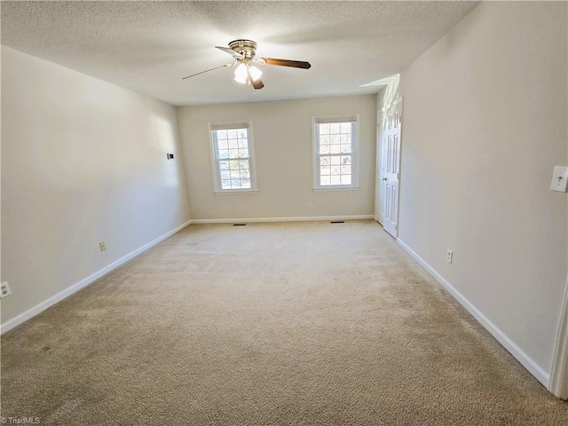 unfurnished room featuring ceiling fan, a textured ceiling, and light carpet