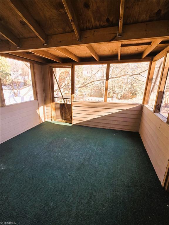 unfurnished sunroom with wooden ceiling and beamed ceiling