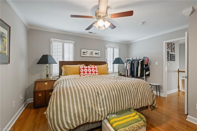 bedroom featuring baseboards, crown molding, visible vents, and wood finished floors