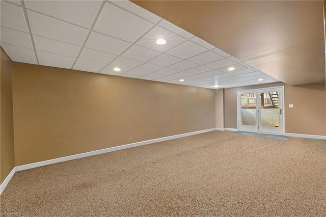 unfurnished room with a paneled ceiling, baseboards, and carpet flooring