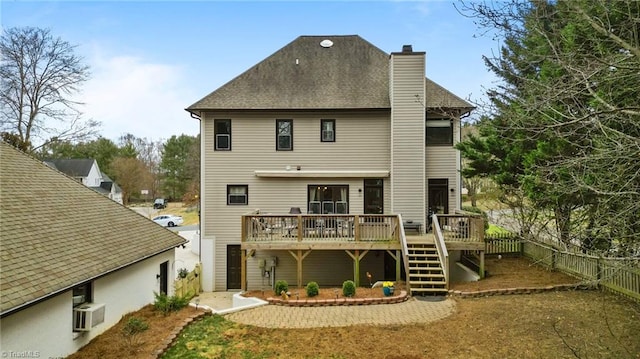 rear view of property with a chimney, a shingled roof, stairway, fence, and a wooden deck