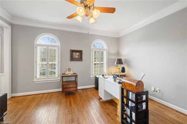 office area with ornamental molding, a ceiling fan, hardwood / wood-style flooring, and baseboards