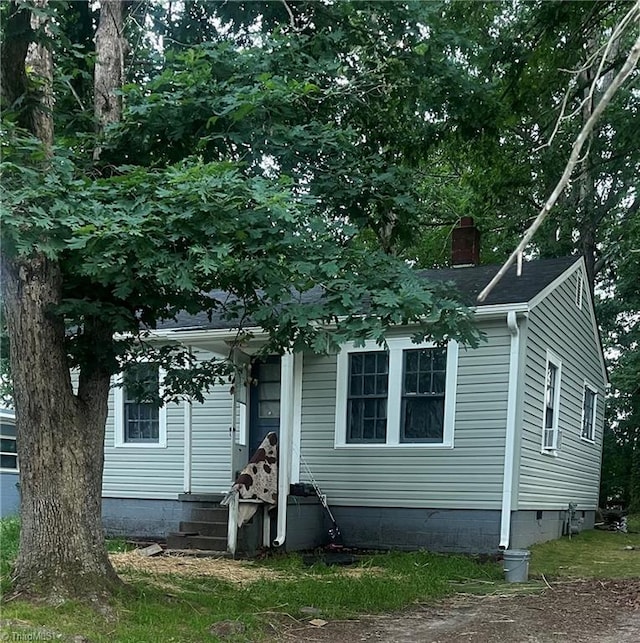 view of front of home with a chimney and crawl space