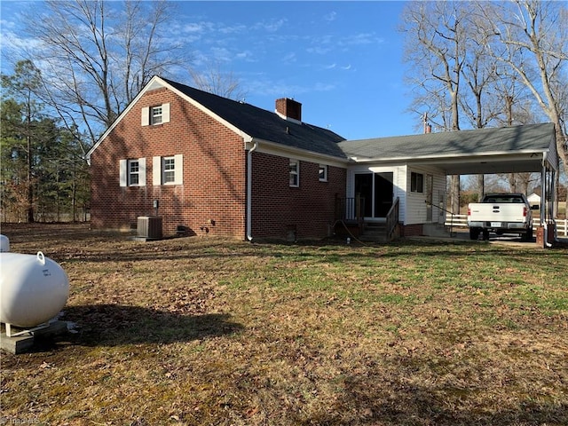 back of property featuring a carport and a yard