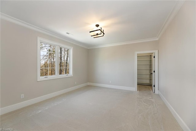 spare room with ornamental molding and light carpet