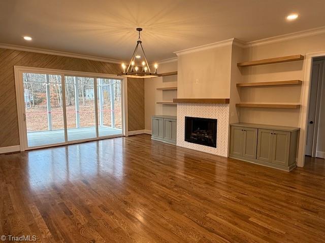 unfurnished living room featuring a tiled fireplace, crown molding, and dark hardwood / wood-style flooring