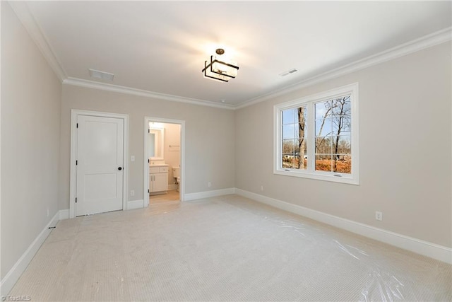 unfurnished bedroom featuring ornamental molding, light colored carpet, and ensuite bathroom