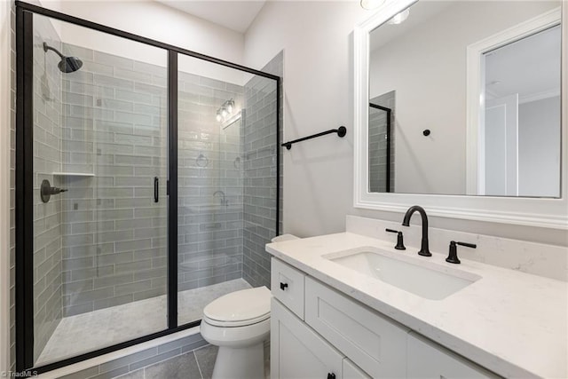 bathroom with a shower with door, vanity, and toilet