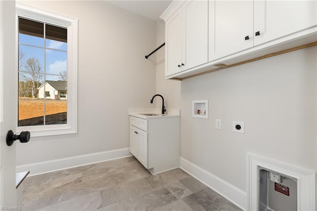 clothes washing area with hookup for a washing machine, electric dryer hookup, sink, and cabinets