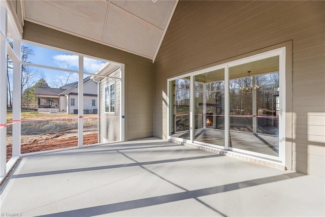 unfurnished sunroom with a healthy amount of sunlight and lofted ceiling