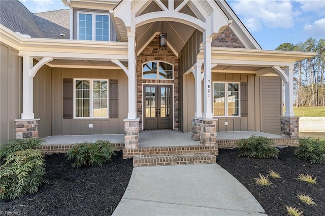 7621 Pemberley Dr, Oak Ridge, NC 27310 - property entrance featuring french doors, board and batten siding, a porch, and roof with shingles