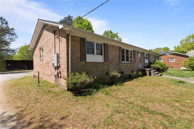 single story home featuring brick siding, cooling unit, driveway, and a front lawn