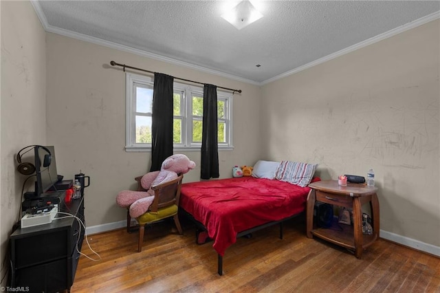 bedroom featuring hardwood / wood-style floors, a textured ceiling, crown molding, and baseboards