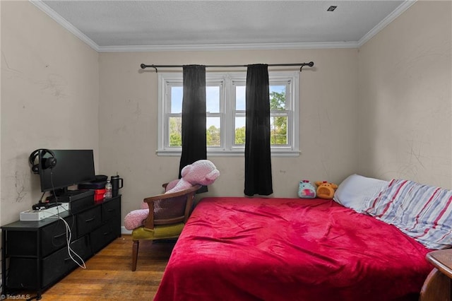 bedroom with crown molding, wood finished floors, and multiple windows