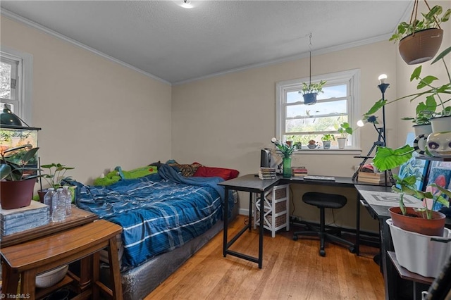 bedroom with wood finished floors and ornamental molding