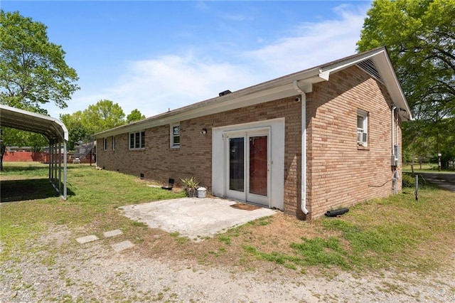 back of house featuring brick siding, a yard, and a patio area
