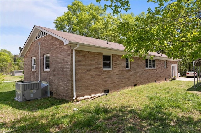 view of side of home featuring brick siding, a yard, central air condition unit, and crawl space