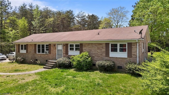 ranch-style house featuring roof with shingles, cooling unit, brick siding, crawl space, and a front yard