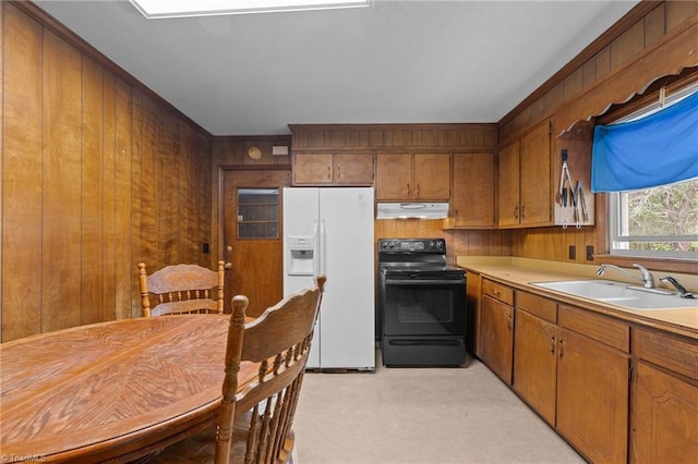 kitchen featuring a sink, white refrigerator with ice dispenser, wood walls, under cabinet range hood, and black range with electric stovetop