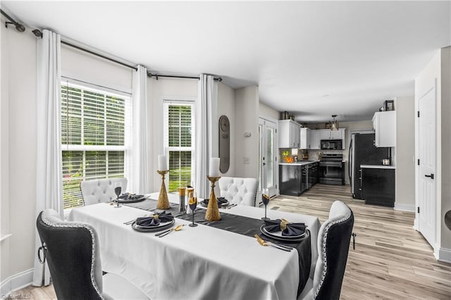 dining area featuring baseboards and light wood-style flooring