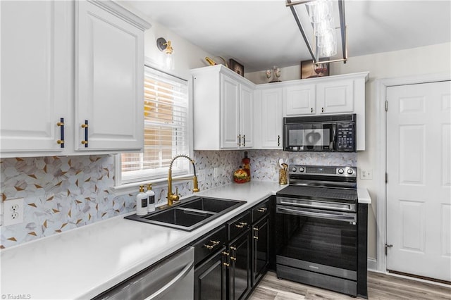 kitchen with a sink, appliances with stainless steel finishes, and white cabinetry