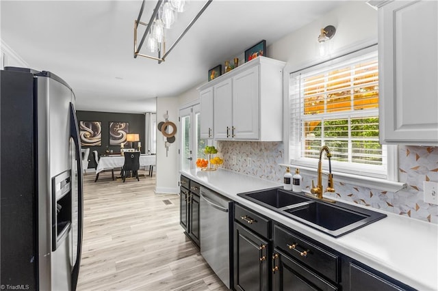 kitchen featuring light countertops, a sink, white cabinetry, and stainless steel appliances