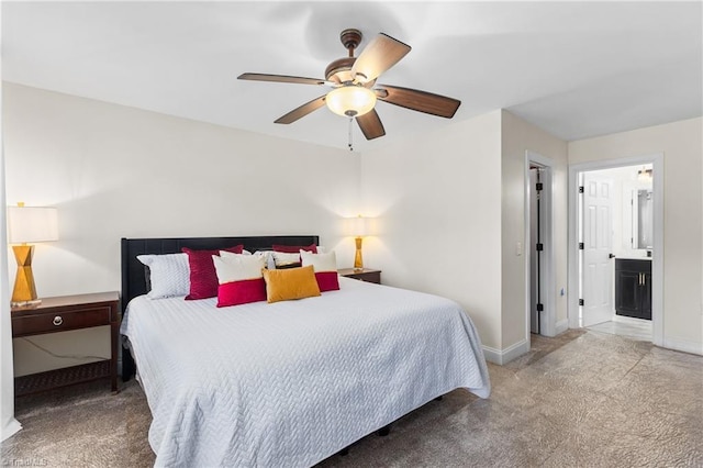 carpeted bedroom featuring baseboards, ceiling fan, and ensuite bath