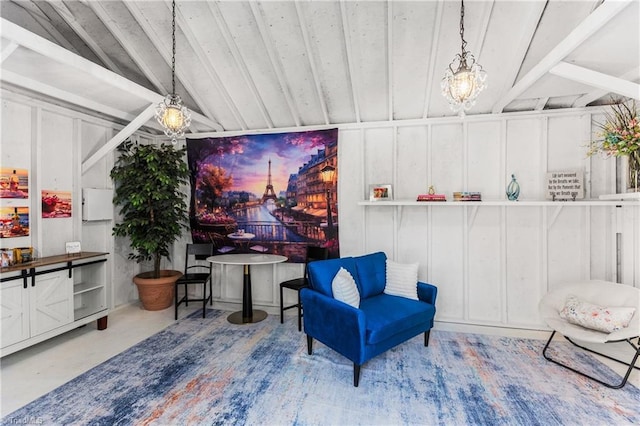sitting room featuring lofted ceiling with beams, a decorative wall, and a notable chandelier