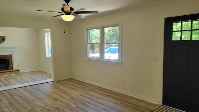 313 Farmstead Rd, King, NC 27021 - unfurnished living room with wood finished floors, crown molding, a glass covered fireplace, and ceiling fan