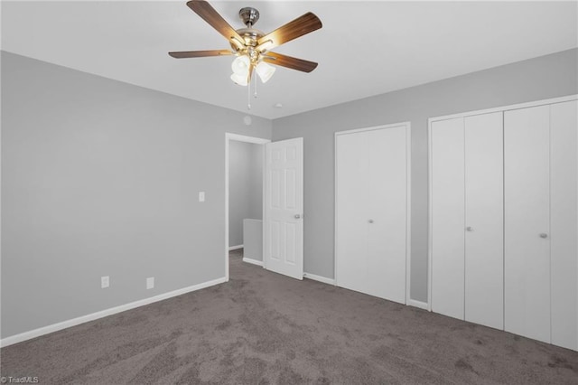 unfurnished bedroom with ceiling fan, carpet floors, and two closets