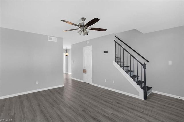 unfurnished living room featuring dark wood-type flooring and ceiling fan with notable chandelier