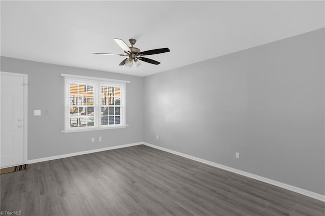 spare room with ceiling fan and dark hardwood / wood-style flooring