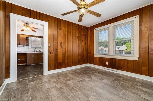 2110 E Green Dr, High Point, NC 27260 - empty room featuring a sink, ceiling fan, wooden walls, and ornamental molding