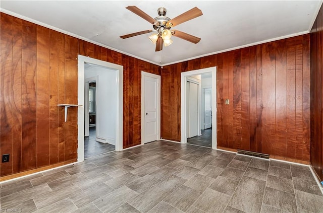 2110 E Green Dr, High Point, NC 27260 - spare room with a ceiling fan, wooden walls, visible vents, and crown molding