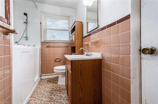 2110 E Green Dr, High Point, NC 27260 - bathroom featuring tile patterned floors, tile walls, a shower, and a healthy amount of sunlight