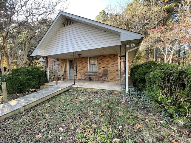 rear view of property featuring covered porch