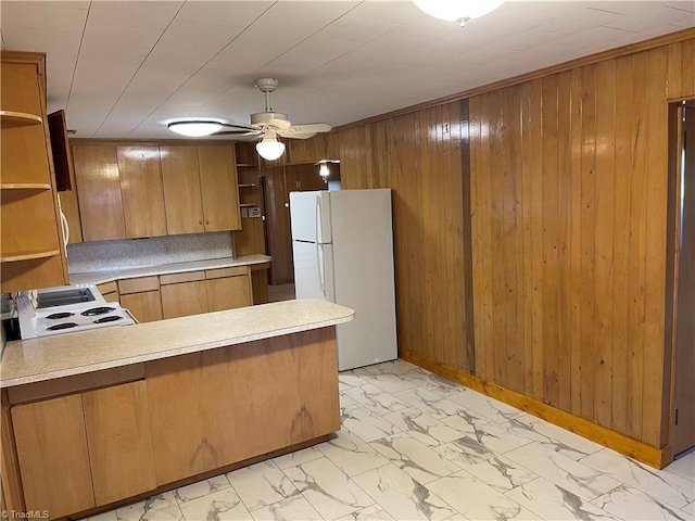 kitchen featuring wooden walls, white appliances, and kitchen peninsula