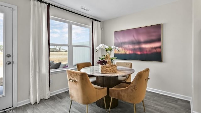 dining space featuring baseboards, visible vents, and wood finished floors