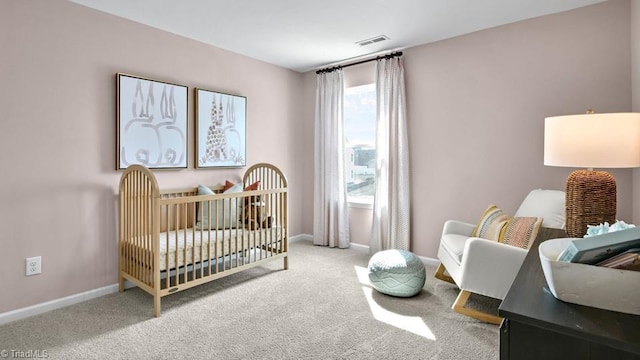 carpeted bedroom featuring baseboards, visible vents, and a nursery area